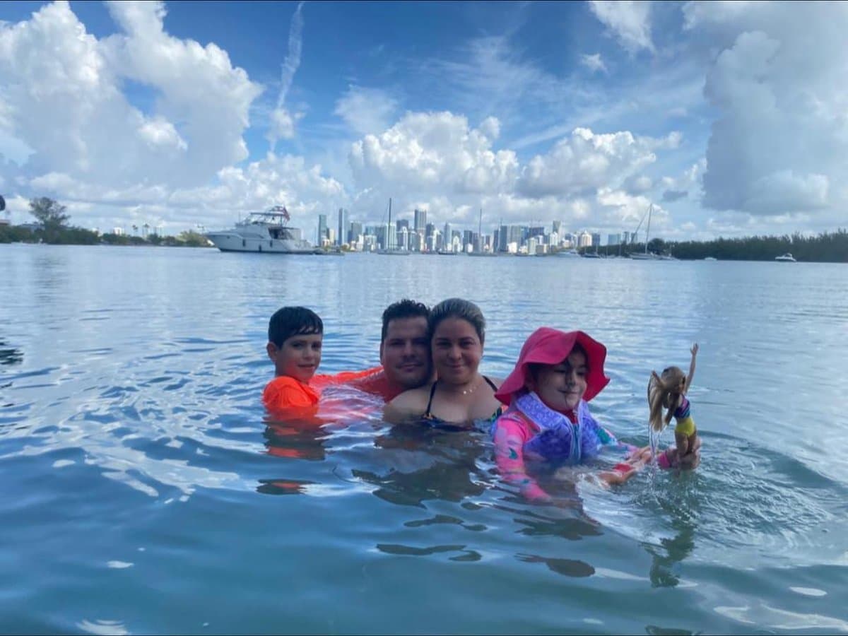 Family swimming at the sandbar with the Miami skyline behind them